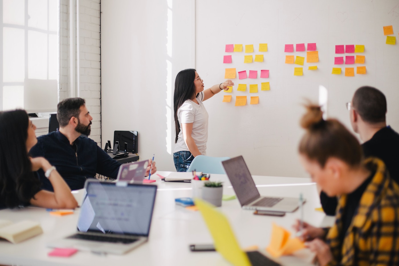 Strategists writing messaging axis notes on a whiteboard during a brand workshop